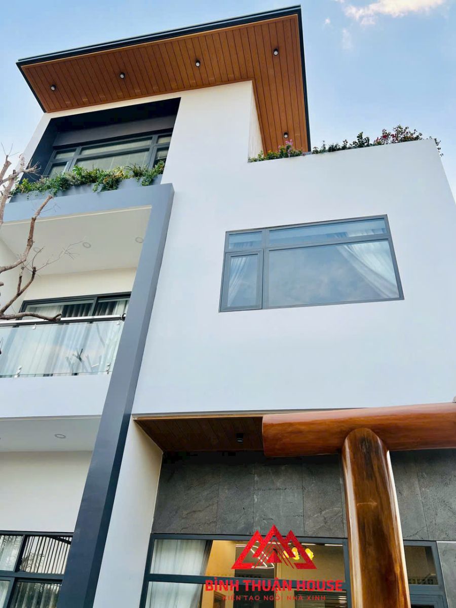 Mặt tiền Tuyết’s Villa với cửa lam gỗ và trần ban công ốp gỗ.